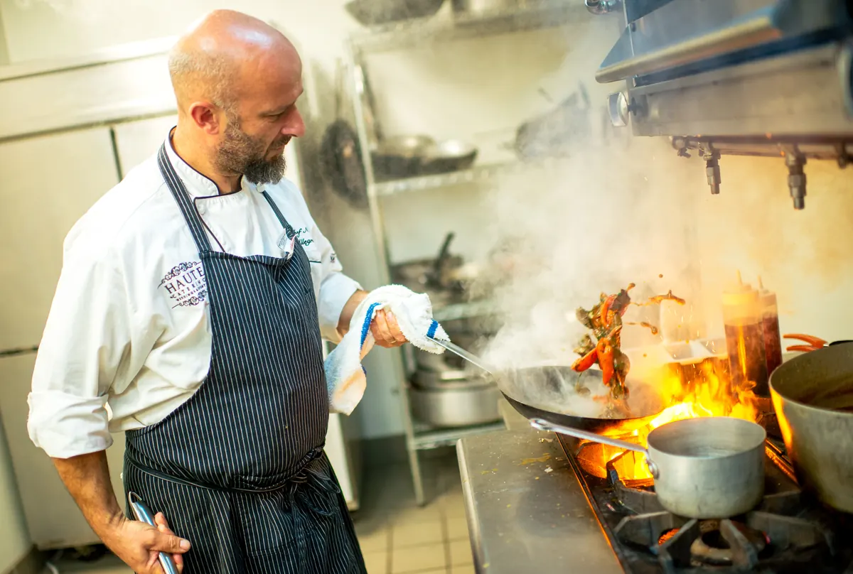 Chef Nicola Allegretta stir-frying over a flaming wok