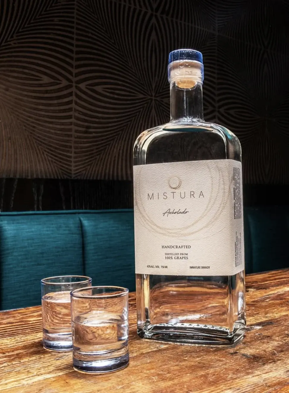 A bottle of Mistura Acholado, house-distilled immature brandy, with two glasses