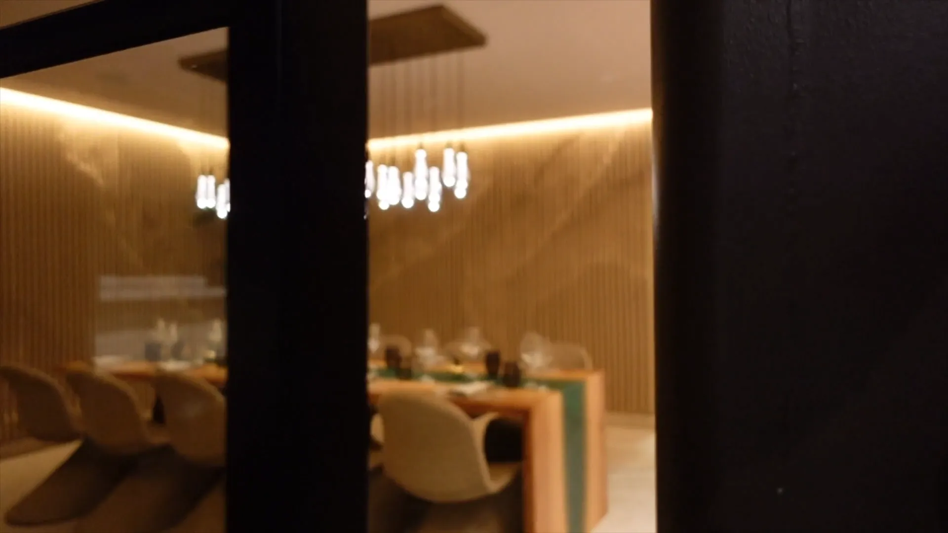 The private dining room at Mistura, lit warmly, seen through an open doorway